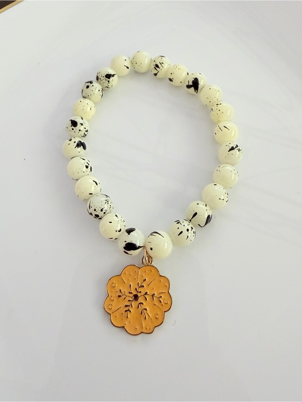 Gold Floral Charm Cream & Black Speckled Bead Stretch Bracelet